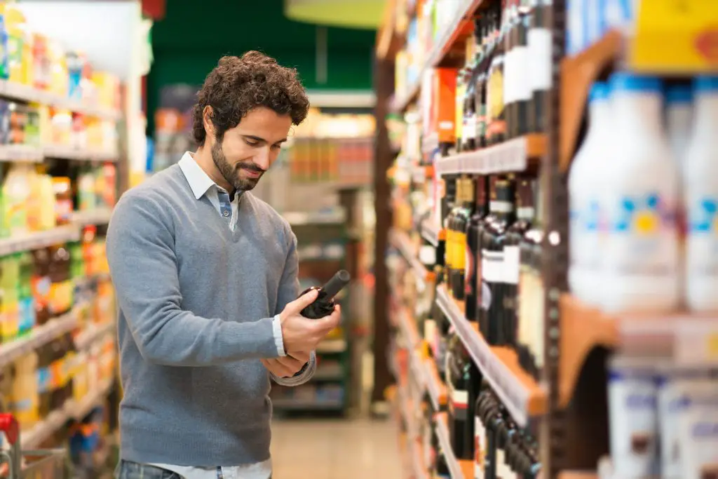 Man choosing a wine bottle of White Zin