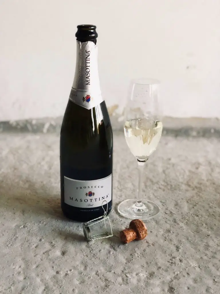 A glass and bottle of prosecco