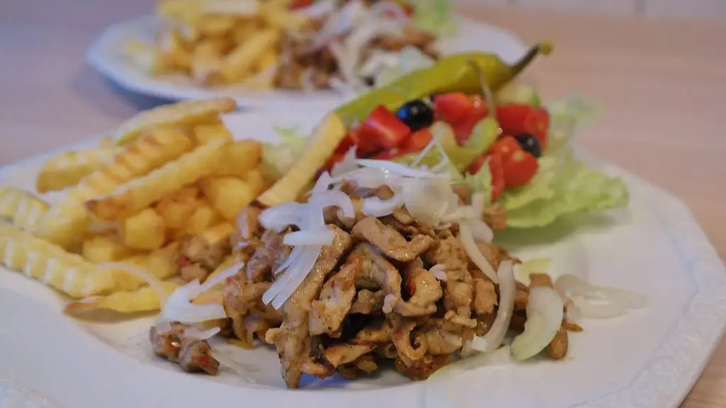 gyros meat with fries, salad and raw onion