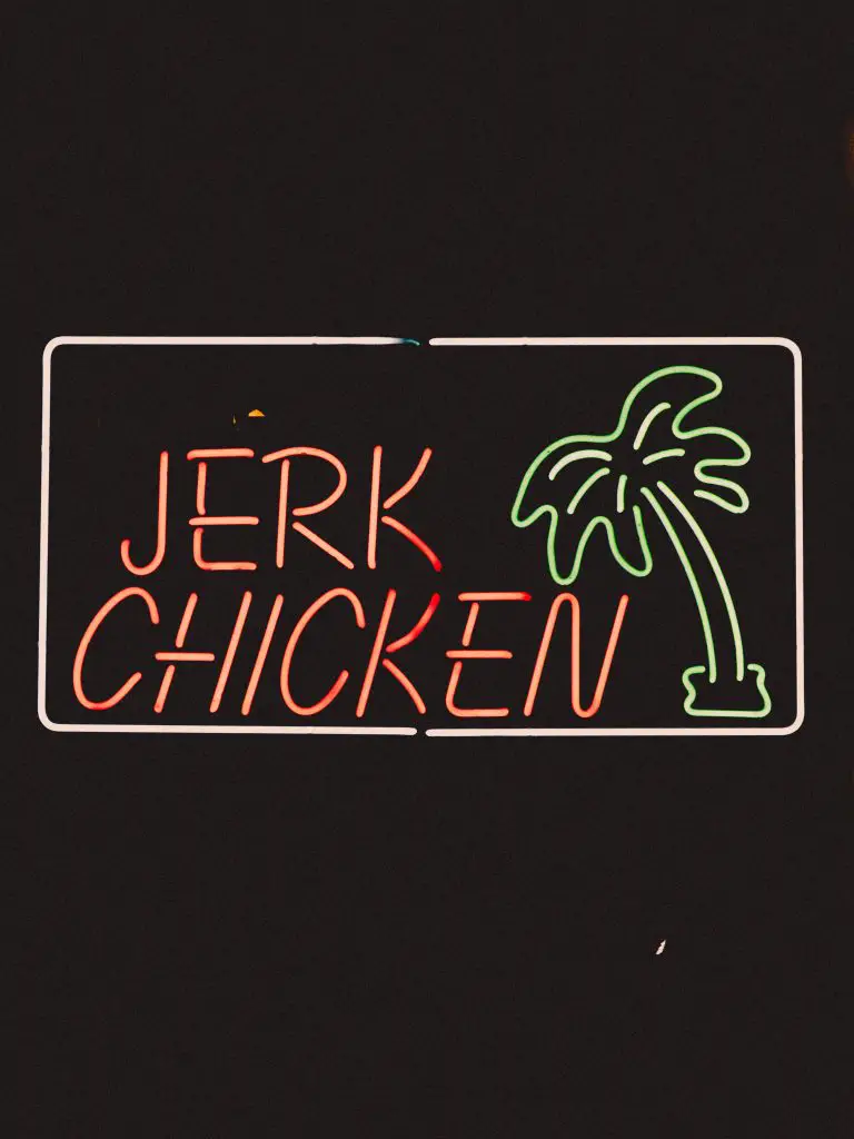 neon jerk chicken sign with island palm tree